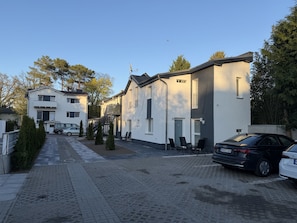 A residential street with houses, parked cars, and a clear sky.
