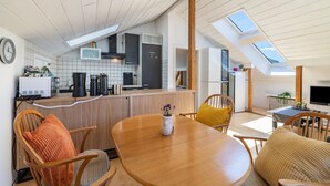 A modern kitchen with a dining area, wooden furniture, and skylights. - Panorama Loft – Scenic Views & Active Getaway at the Foot of the Swabian Alb (Lichtenstein)