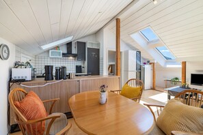 Una cocina moderna con comedor, muebles de madera y tragaluces.