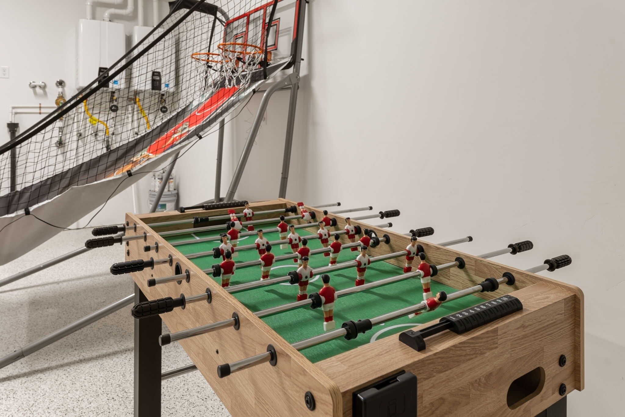 A foosball table with a green playing surface and red and white player figures.