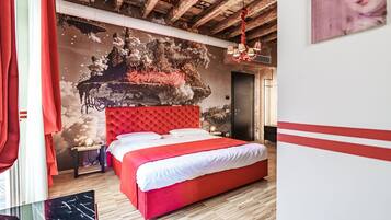 A bedroom with a red bed, a mural on the wall, and a wooden ceiling.