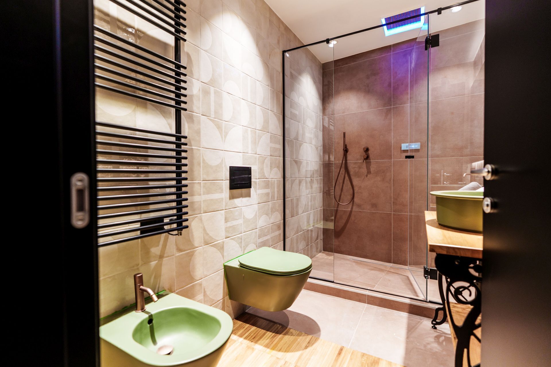 Een moderne badkamer met een douche, een groene wastafel en een toilet.