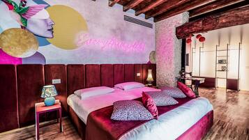 Ein modernes Schlafzimmer mit einem großen Bett, einer Neonleuchtreklame und einer außergewöhnlichen Wandmalerei.
