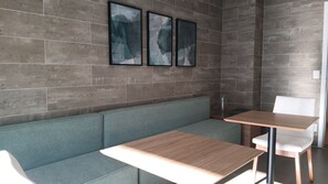 A modern interior with a grey sofa, a wooden table, and a white chair. - Vista incrível com AC e academia (São Paulo)