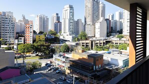 Un paisaje urbano con edificios altos, un estacionamiento y una pasarela peatonal.