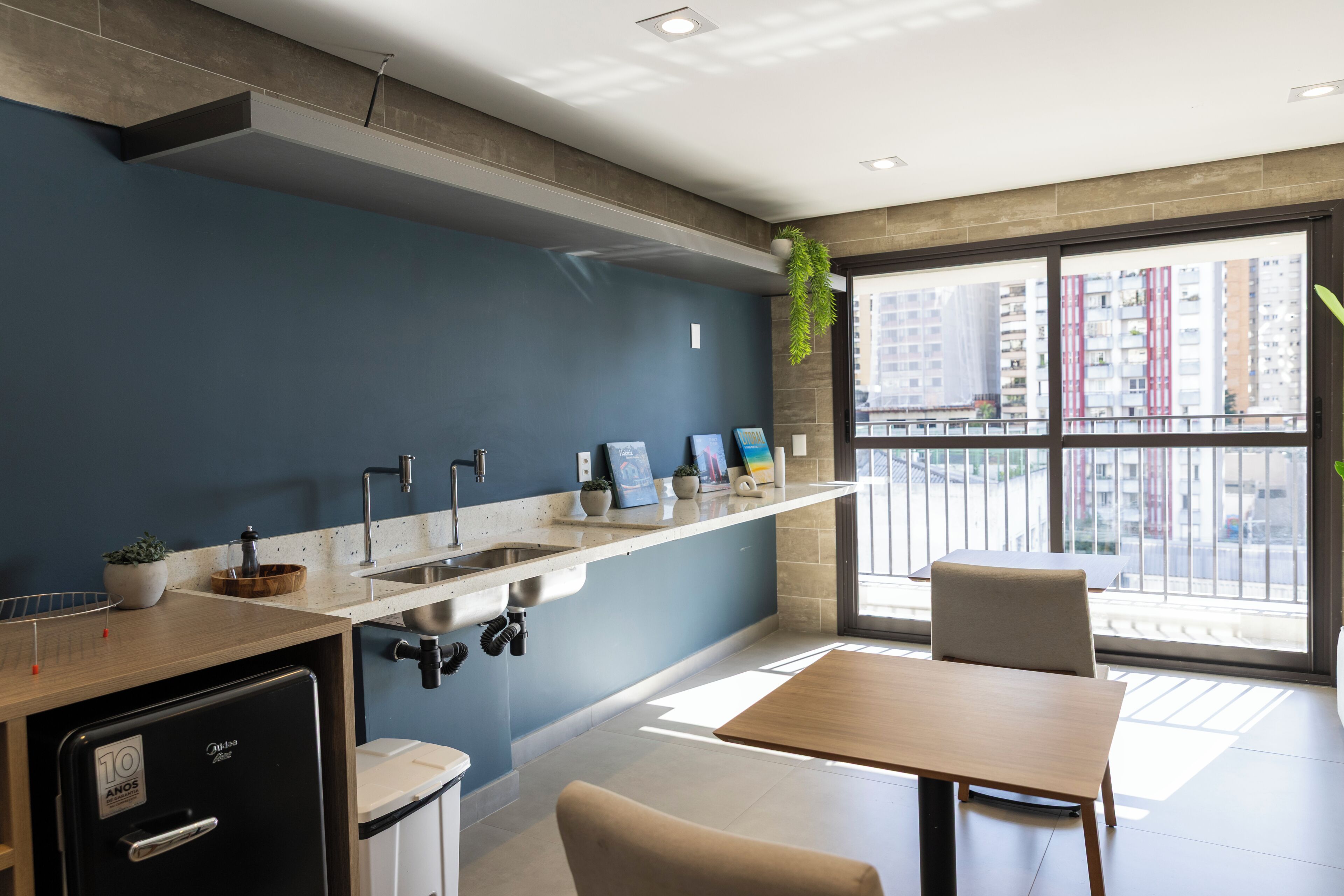 A modern kitchen with a built-in sink, a refrigerator, and a dining area with a table and chairs.