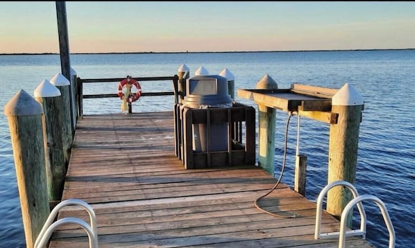 A wooden pier with a metal grill and a television.