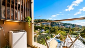 Ein Balkon mit Blick auf eine Stadtlandschaft, ein Ventilator und ein kleines Gerät.