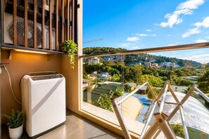 Ein Balkon mit Blick auf eine Stadtlandschaft, ein Ventilator und ein kleines Gerät.
