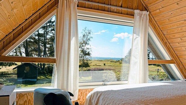 A cozy bedroom with a large window, wooden ceiling, and a bed. - 4 Star Holiday Home in Sydals (Sydals)