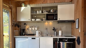 A compact kitchen with a dishwasher, oven, microwave, and a small sink. - 4 Star Holiday Home in Sydals (Sydals)