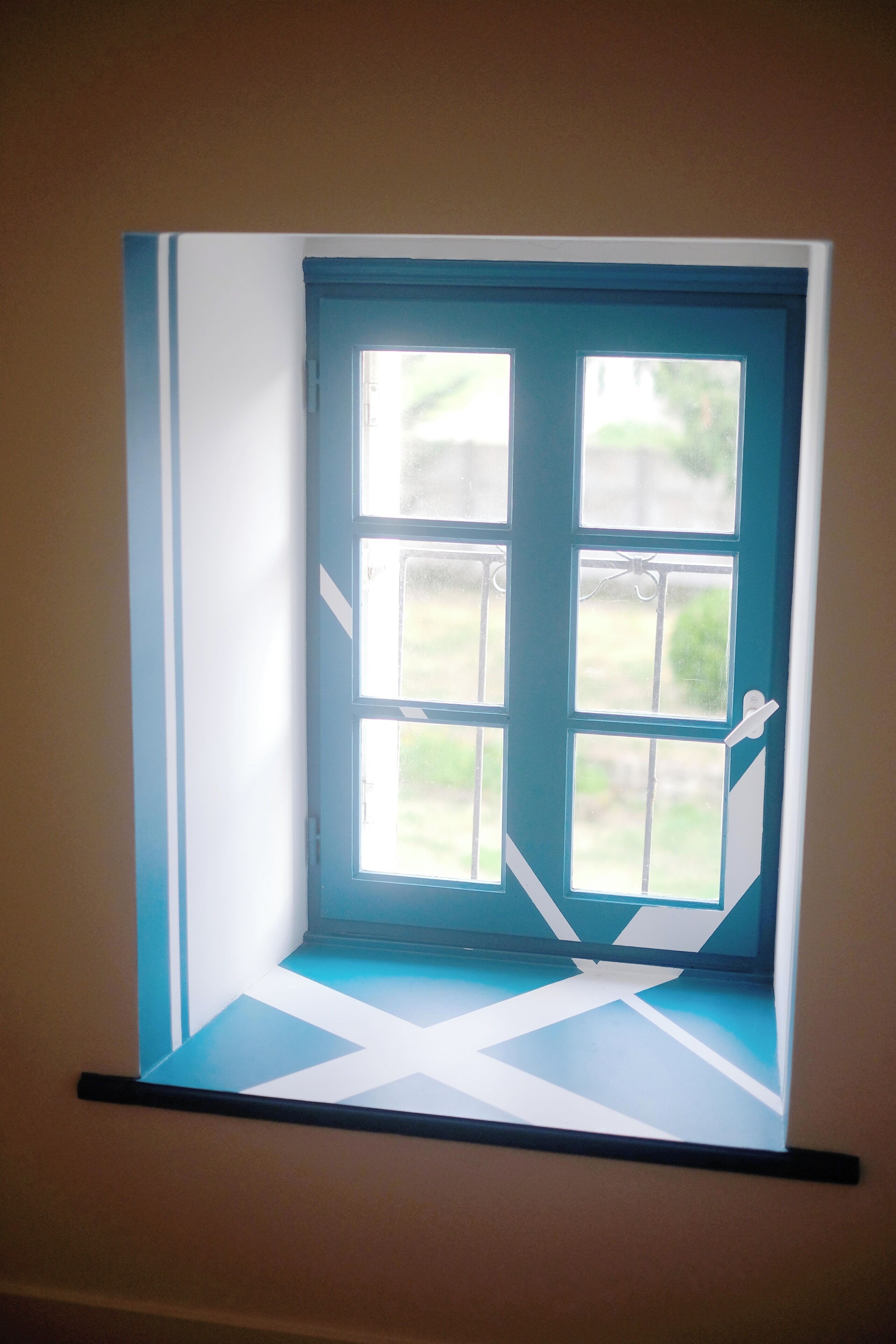 A window with a view of greenery outside.