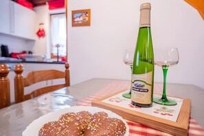 Et spisebord med en hvid vinflaske, to vinglas og en tallerken med pyntede kager.
