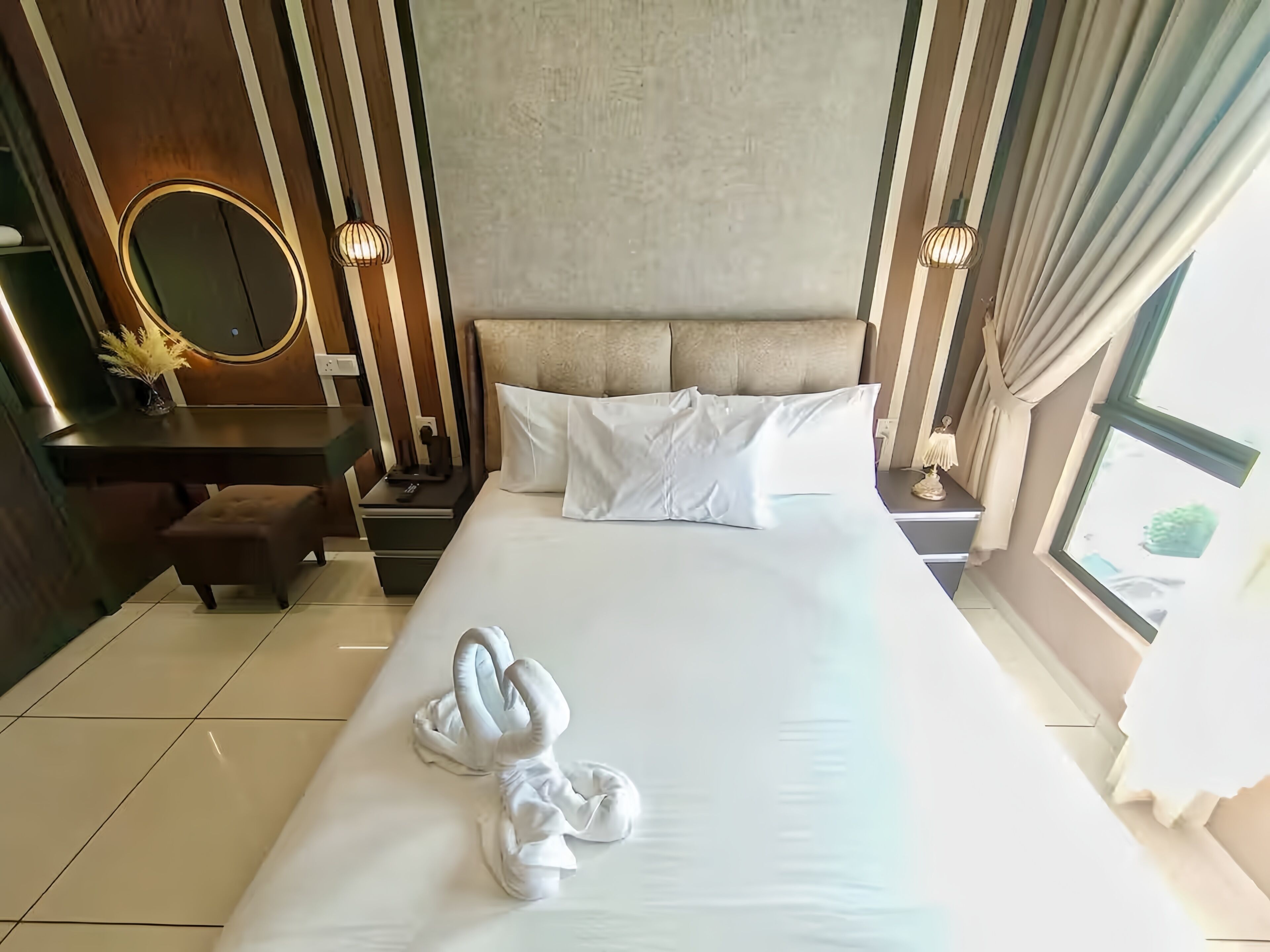 Une chambre d’hôtel avec un grand lit, une table de chevet, un miroir et une fenêtre.