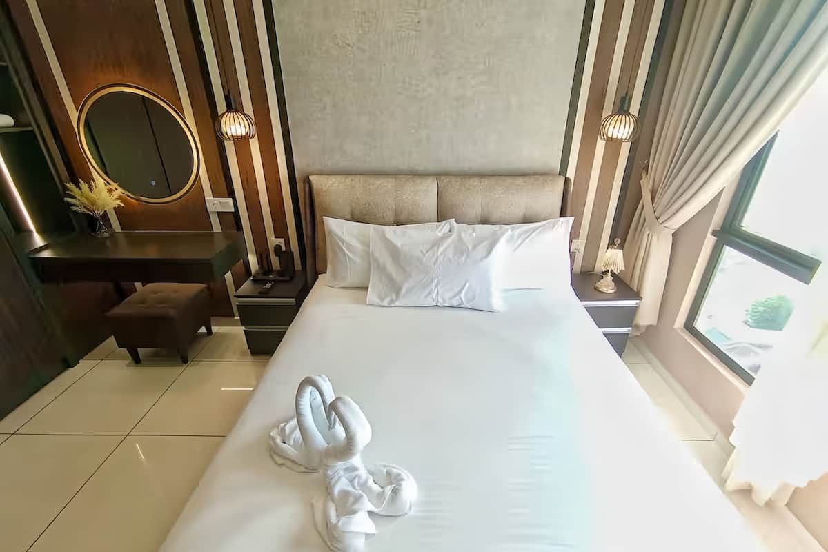 Une chambre d’hôtel avec un grand lit, une table de chevet, un miroir et une fenêtre.
