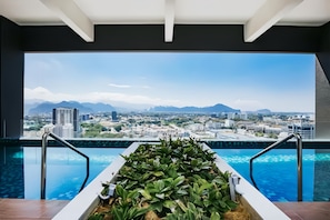 Une piscine avec vue sur le paysage urbain et les montagnes.