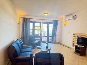 A living room with a sofa, a coffee table, a TV stand, and a fireplace. - New, Villa With a View, new Design- Pics in a few Days (Mombasa)
