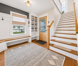 A staircase with wooden steps and a handrail, leading to a door with a frosted glass panel. - Coastal Waterfront Escape w/ Boat Dock (Long Branch)