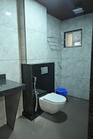 Un baño pequeño con inodoro, ducha y lavamanos.