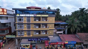 A multi-story building with a sign for 'Kamath Yatri Nivas' indicating it is a lodging and restaurant. - Kamath Yatri Nivas Plus (Bhatkal)