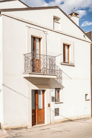 A two-story building with a balcony, a door, and a window. - La Casa di Zia Rita (San Giacomo degli Schiavoni)
