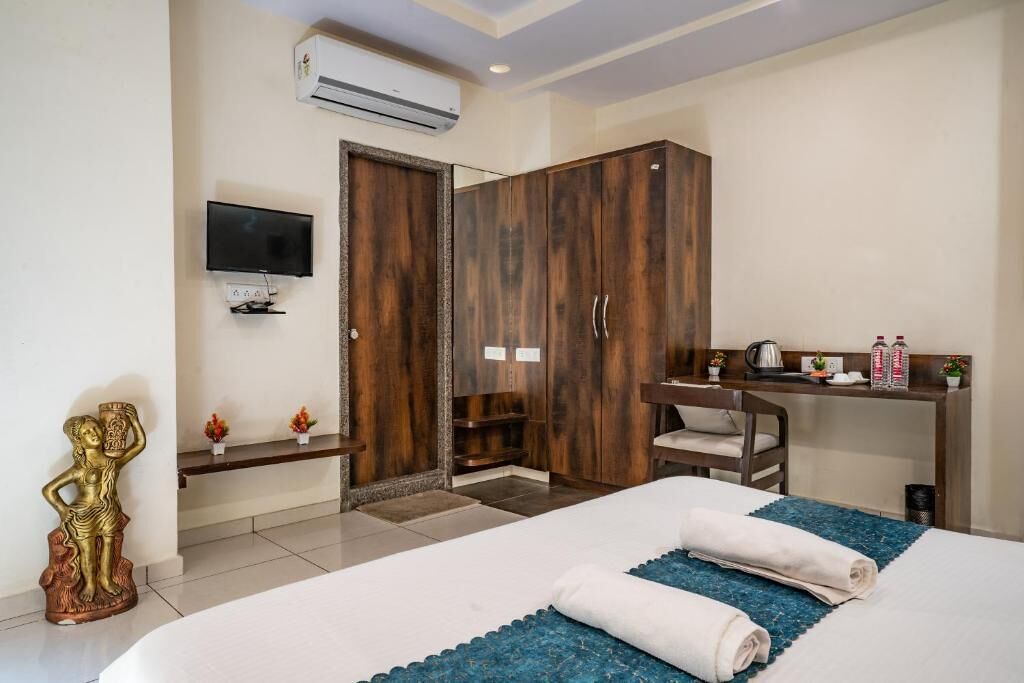 Une chambre d’hôtel avec un lit, un bureau, une télévision et une armoire.