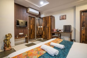 Une chambre d’hôtel équipée d’un lit, d’un bureau, d’une télévision et d’une armoire.