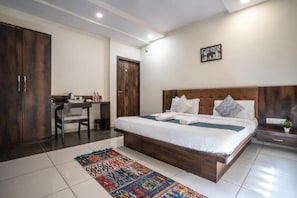 Une chambre à coucher avec un grand lit, un bureau et une armoire.