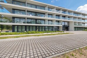 En bygning med flere etager i moderne design, med store vinduer og en belagt gangsti.