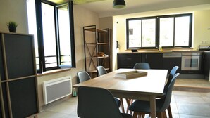 Une cuisine moderne avec une table à manger, des chaises et un four encastré.