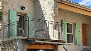 A stone building with a balcony, a wooden staircase, and a stone pillar. - ⭐​ The Colibris Loft ⭐​ (Mirabel-et-Blacons)