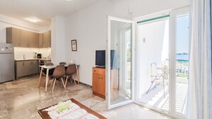 Een modern appartement met een keuken, eethoek en balkon met uitzicht.