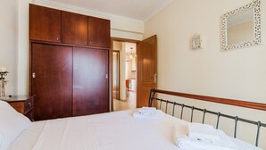 A hotel room with a large bed, wooden wardrobe, and a mirror on the wall. - Nerea Beach House by Rentals Pro - Mouries Halkidiki (Mouries)