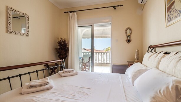 A hotel room with a bed, a window, a balcony, and a door. - Nerea Beach House by Rentals Pro - Mouries Halkidiki (Mouries)
