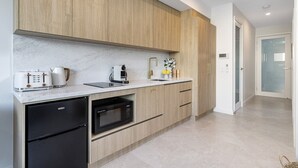 Una cuina moderna amb armaris de fusta, rentaplats integrat, microones i cafetera.