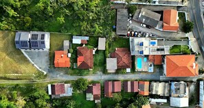An aerial view of a residential area with houses, a swimming pool, and a solar panel installation. - 2 Premium Bedrooms, 2nd Floor, Sea and Park View (Penha)