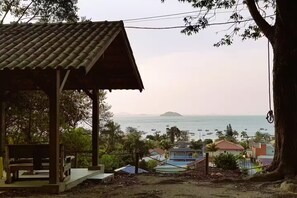 A wooden structure with a tiled roof overlooking a coastal area with boats and houses. - 2 Premium Bedrooms, 2nd Floor, Sea and Park View (Penha)