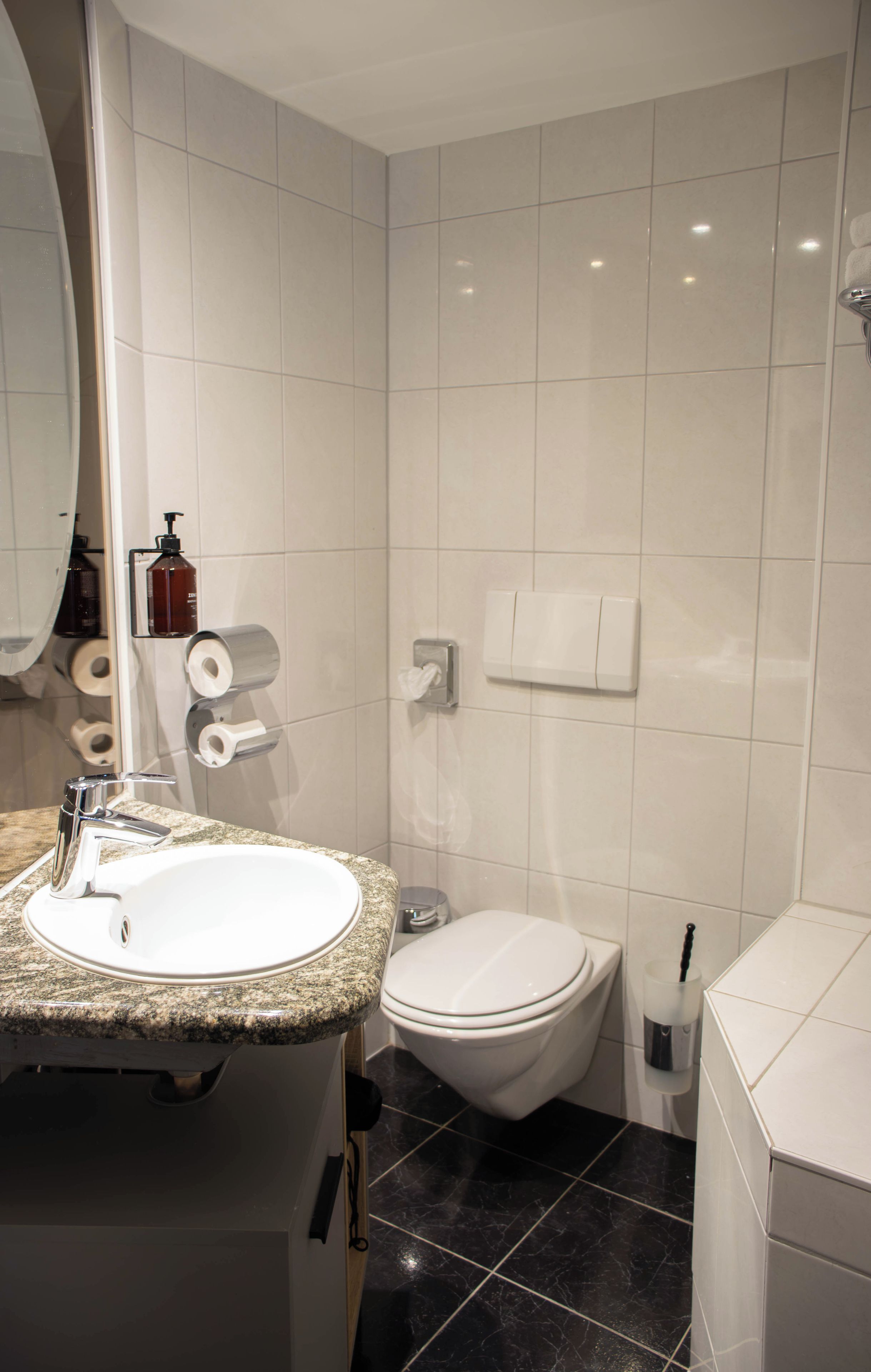 Un baño con lavamanos, inodoro y espejo.
