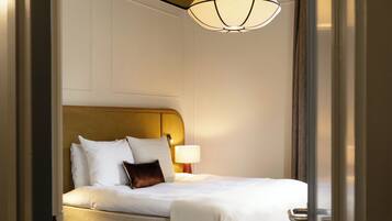 Une chambre à coucher avec un lit, une table de chevet, une lampe et un luminaire suspendu.
