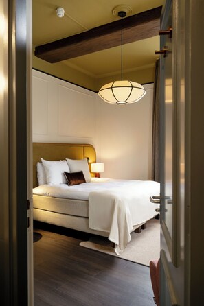 Un dormitorio con cama, mesita de noche, lámpara y una lámpara colgante.