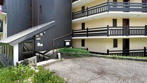 Un edificio de varios pisos con balcones, una escalera y un patio de grava.