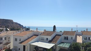 A coastal residential area with terracotta-tiled rooftops, a prominent lighthouse, and a clear view of the sea. - CASA 8 - Sea View T3 (Luz)
