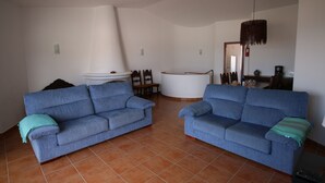 A living room with two blue sofas, a white coffee table, and a large white cabinet. - CASA 8 - Sea View T3 (Luz)