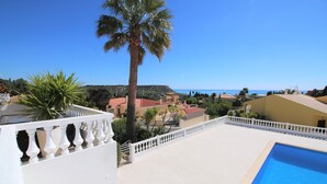 Ein Poolbereich mit freiem Blick auf das Meer und die umliegenden Gebäude.