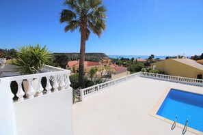 A pool area with a clear view of the sea and surrounding buildings. - VILLA VANGOH T2 Sunnypool (Luz)
