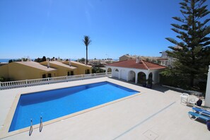 A swimming pool with a clear blue water, surrounded by a white fence and a few potted plants. - VANGOH T2 Sunnypool (Luz)