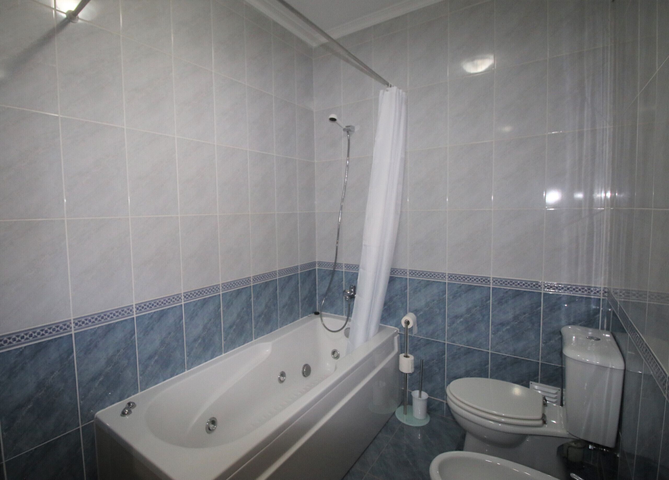 A bathroom with a bathtub, toilet, and shower.