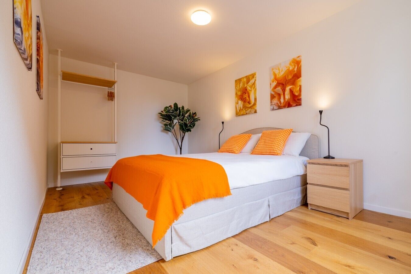 Ein Schlafzimmer mit einem Bett, einem Nachttisch, einer Kommode und einem Spiegel.