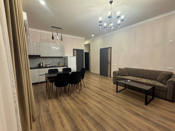 A modern living room with a sofa and a dining table with chairs.