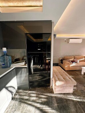 A modern living space with a kitchen, a sofa, and a water dispenser. - Peaceful Holiday Villas-luxury (Serik)